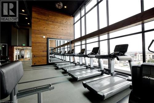Fitness facility with floor-to-ceiling windows, wood-paneled accent wall, and recessed lighting - 330 Phillip Street Unit# S605, Waterloo, ON - Indoor Photo Showing Gym Room