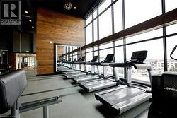 Fitness facility with floor-to-ceiling windows, wood-paneled accent wall, and recessed lighting - 