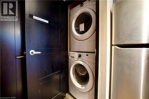 Stackable washer and dryer appliances within a dedicated recess - 330 Phillip Street Unit# S605, Waterloo, ON - Indoor Photo Showing Laundry Room