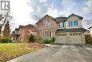 Two-story brick and siding residence featuring a two-car garage with individual doors, a paved driveway, and mature landscaping - 711 Cedar Bend Drive, Waterloo, ON  - Outdoor With Facade 