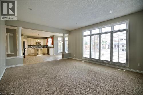Spacious room featuring neutral carpeting, a large multipane window with plantation shutters, and recessed lighting - 711 Cedar Bend Drive, Waterloo, ON - Indoor Photo Showing Other Room
