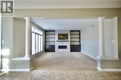 Spacious living area featuring a stone-clad fireplace, integrated shelving, and built-in cabinetry - 711 Cedar Bend Drive, Waterloo, ON - Indoor With Fireplace
