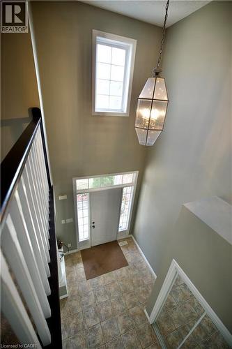 Soaring foyer with a striking pendant light fixture, high window, and a white front door featuring sidelights and a transom - 711 Cedar Bend Drive, Waterloo, ON - Indoor Photo Showing Other Room