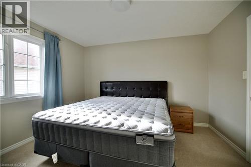 Carpeted room featuring a double-paned window with grid inserts, neutral wall color, and white trim - 711 Cedar Bend Drive, Waterloo, ON - Indoor Photo Showing Bedroom