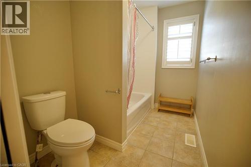 Full bathroom featuring a white tub, shower rod, and a window with white shutters - 711 Cedar Bend Drive, Waterloo, ON - Indoor Photo Showing Bathroom