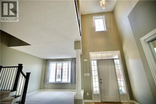 Two-story foyer with transom window and sidelights, featuring a prominent column and a decorative pendant light fixture - 711 Cedar Bend Drive, Waterloo, ON - Indoor Photo Showing Other Room