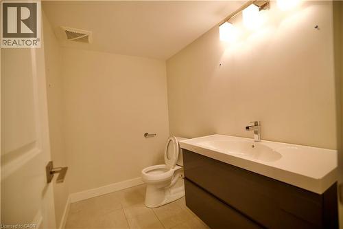 Bathroom featuring a floating vanity with integrated sink, chrome faucet, and overhead vanity lighting - 711 Cedar Bend Drive, Waterloo, ON - Indoor Photo Showing Bathroom