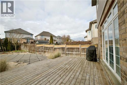 Spacious backyard featuring a large wooden deck, full-height windows, a covered pool area, brick exterior siding, and a wood privacy fence with lattice detailing - 711 Cedar Bend Drive, Waterloo, ON - Outdoor With Deck Patio Veranda With Exterior