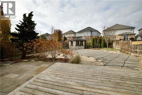 Expansive backyard featuring a wood deck, stone patio, and a covered inground pool - 711 Cedar Bend Drive, Waterloo, ON - Outdoor