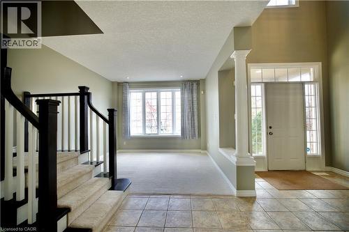 Two-story foyer with ceramic tile flooring, a prominent decorative column, and a front entry door with transom and sidelight windows - 711 Cedar Bend Drive, Waterloo, ON - Indoor Photo Showing Other Room