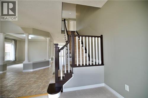 Curved staircase with dark wood railing and white balusters - 711 Cedar Bend Drive, Waterloo, ON - Indoor Photo Showing Other Room