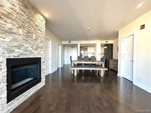 Overall view - 711-2160 Av. Terry-Fox, Laval (Chomedey), QC - Indoor Photo Showing Living Room With Fireplace