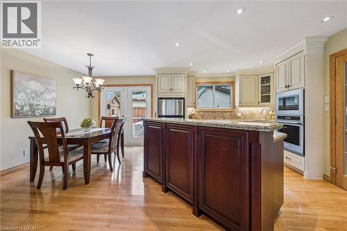 Kitchen island with dark wood-finish cabinetry and a light-toned countertop - 574 Sprucehill Avenue, Waterloo, ON - Indoor