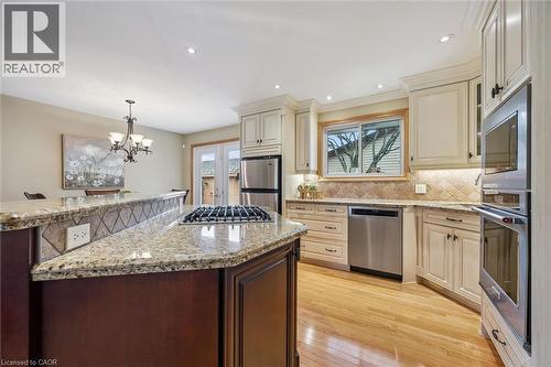 Kitchen with granite countertops, stainless steel appliances, light wood-finish flooring, recessed lighting, and a built-in gas range on the island - 574 Sprucehill Avenue, Waterloo, ON - Indoor Photo Showing Kitchen With Upgraded Kitchen