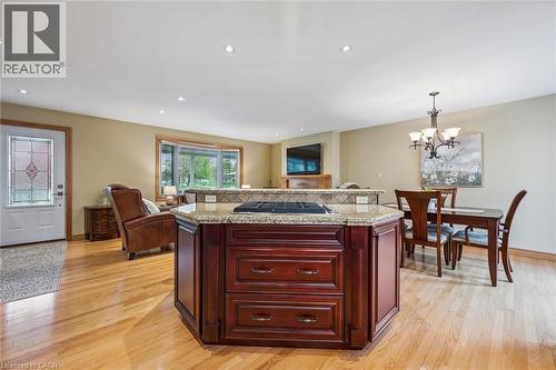 Kitchen island with granite countertop, integrated cooktop, and rich wood cabinetry - 574 Sprucehill Avenue, Waterloo, ON - Indoor