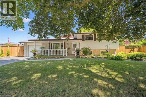 Split-level residence featuring a brick and siding exterior, an attached garage, and a covered porch with white railings - 574 Sprucehill Avenue, Waterloo, ON - Outdoor With Deck Patio Veranda
