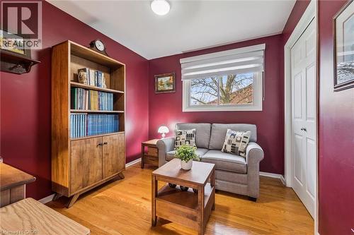 Inviting room featuring rich wall color, wood-finish flooring, and a bright window with a roller shade - 574 Sprucehill Avenue, Waterloo, ON - Indoor