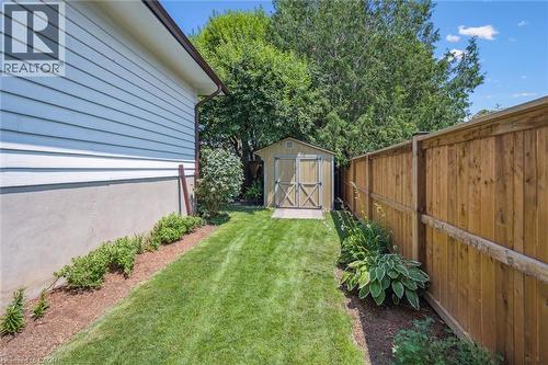 Side yard featuring a wooden privacy fence, manicured lawn, and a functional storage shed - 574 Sprucehill Avenue, Waterloo, ON - Outdoor