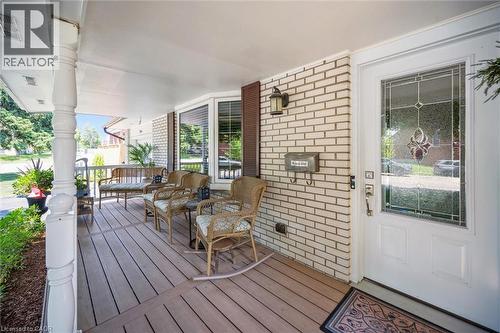 Inviting front porch featuring a white brick facade and wood-finish decking - 574 Sprucehill Avenue, Waterloo, ON - Outdoor With Deck Patio Veranda