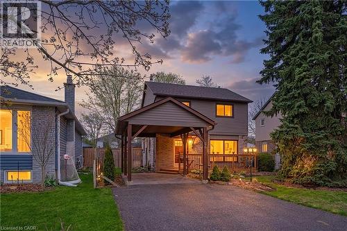 Two-story residence featuring a carport, brick and siding exterior, a front deck with railings, and established landscaping - 56 Angela Crescent, Cambridge, ON - Outdoor With Deck Patio Veranda