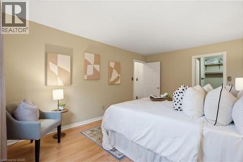 Bright primary bedroom with light wood-finish flooring, neutral-toned walls and walk-in closet - 56 Angela Crescent, Cambridge, ON - Indoor Photo Showing Bedroom