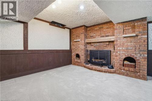 Brick gas fireplace with a stone mantel, hearth, and arched wood storage niches - 56 Angela Crescent, Cambridge, ON -  With Fireplace