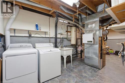 Utility area featuring a washer and dryer, a utility sink, a water heater, and exposed overhead ductwork - 56 Angela Crescent, Cambridge, ON - Indoor Photo Showing Laundry Room