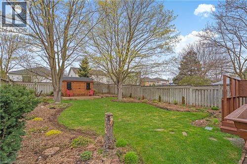Expansive lawn area featuring mature trees and a dedicated garden shed with a small wooden deck - 56 Angela Crescent, Cambridge, ON - Outdoor With Backyard