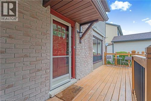 Front entry with a red door, brick facade, and a wood-finish deck - 56 Angela Crescent, Cambridge, ON - Outdoor With Deck Patio Veranda With Exterior