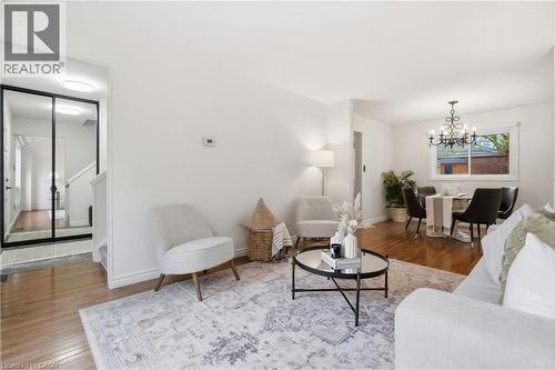 Light-filled living area featuring wood-finish flooring, freshly painted  walls, and a dedicated dining space with a window - 56 Angela Crescent, Cambridge, ON - Indoor Photo Showing Living Room