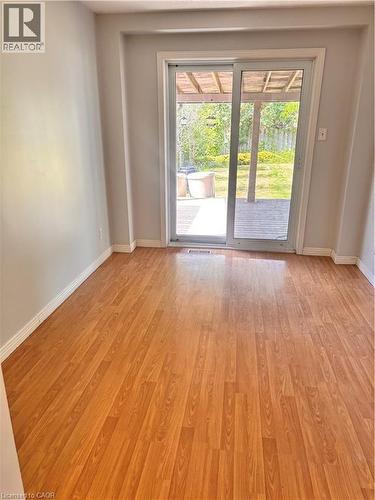 Bright interior space featuring wood-finish flooring and a sliding glass door leading to an outdoor deck - 206 Northmanor Crescent, Kitchener, ON 