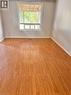 Spacious interior room featuring wood-finish flooring, a large window, and light-toned wall finishes - 206 Northmanor Crescent, Kitchener, ON 