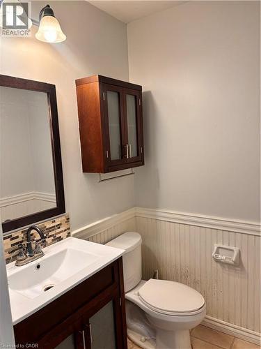 Bathroom vanity with dark wood-finish cabinet, integrated sink, and mosaic tile backsplash - 206 Northmanor Crescent, Kitchener, ON 