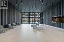 Spacious lobby featuring floor-to-ceiling windows, light-toned tile flooring, contemporary slat wall design, integrated ceiling lighting, and a reception desk with matching slat detailing - 500 Wilson Avenue Unit# 614, Toronto, ON  - Indoor Photo Showing Other Room 