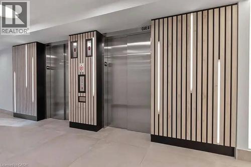 Elevator lobby featuring two stainless steel elevators, wood slat accent walls with integrated vertical lighting, and light-toned floor tiling - 500 Wilson Avenue Unit# 614, Toronto, ON - Indoor Photo Showing Other Room