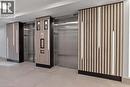 Elevator lobby featuring two stainless steel elevators, wood slat accent walls with integrated vertical lighting, and light-toned floor tiling - 500 Wilson Avenue Unit# 614, Toronto, ON  - Indoor Photo Showing Other Room 