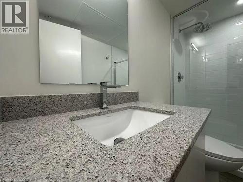 Bathroom vanity featuring a speckled countertop, integrated rectangular sink, and chrome faucet - 500 Wilson Avenue Unit# 614, Toronto, ON - Indoor Photo Showing Bathroom