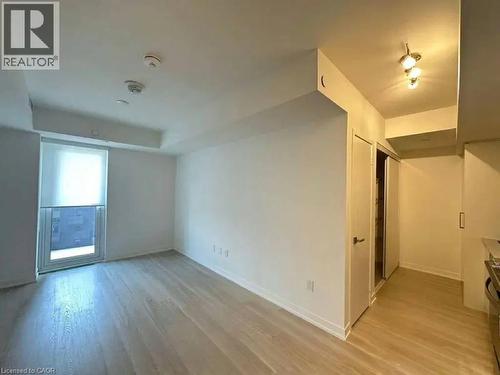 Open-concept living area featuring wood-finish flooring, a large window with roller shades, and white walls - 500 Wilson Avenue Unit# 614, Toronto, ON - Indoor Photo Showing Other Room