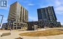 Contemporary urban development featuring two multi-story buildings with dark facades and multiple balconies - 4878 Powers Common Unit# 301, Burlington, ON  - Outdoor With Balcony With Facade 