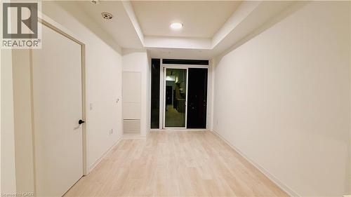 Open living space featuring light wood-finish flooring, recessed ceiling lighting, and a sliding glass door - 4878 Powers Common Unit# 301, Burlington, ON - Indoor Photo Showing Other Room