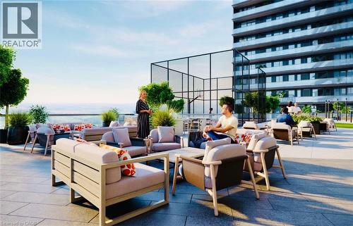 Spacious rooftop patio featuring multiple lounge seating areas, a paved surface, perimeter landscaping, and an adjacent multi-sport court - 4878 Powers Common Unit# 301, Burlington, ON - Outdoor