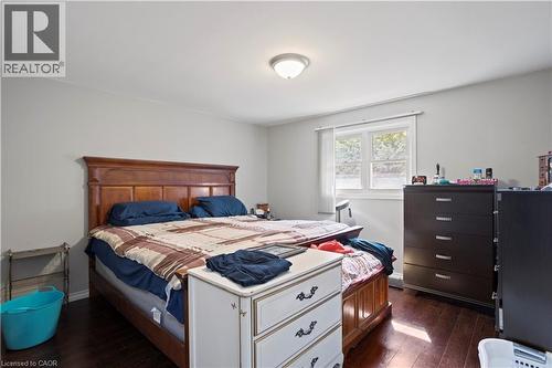 Spacious room featuring dark wood-finish flooring, light gray walls, a window with white trim, and a flush-mount ceiling light fixture - 179 Vancouver Street, London, ON - Indoor Photo Showing Bedroom