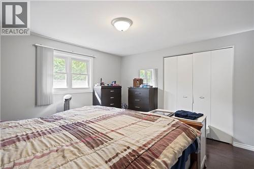 Bright room with a window providing outdoor views, featuring wood-finish flooring and a ceiling-mounted light fixture - 179 Vancouver Street, London, ON - Indoor Photo Showing Bedroom