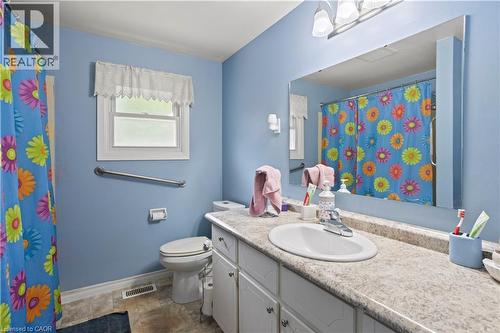 Bathroom featuring a vanity with an integrated sink, a large wall-mounted mirror, and white cabinetry - 179 Vancouver Street, London, ON - Indoor Photo Showing Bathroom