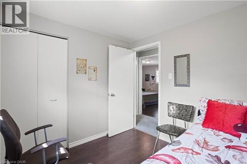 Room featuring dark wood-finish flooring, light-toned wall paint, and a white baseboard trim - 179 Vancouver Street, London, ON - Indoor Photo Showing Bedroom