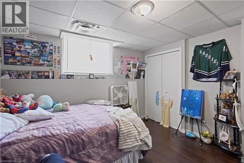 Room featuring wood-finish flooring, a drop ceiling, and a single window with blinds - 179 Vancouver Street, London, ON - Indoor Photo Showing Bedroom