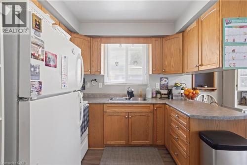 Kitchen featuring wood-finish cabinetry and a window above the sink - 179 Vancouver Street, London, ON - Indoor Photo Showing Kitchen With Double Sink