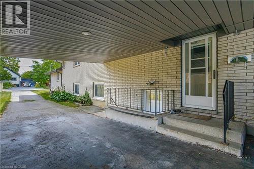 Covered carport parking area with overhead lighting, leading to a brick-clad exterior - 179 Vancouver Street, London, ON - Outdoor With Exterior
