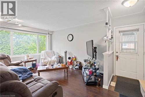 Living area featuring wood-finish flooring, a large window, and a paneled entry door - 179 Vancouver Street, London, ON - Indoor Photo Showing Living Room