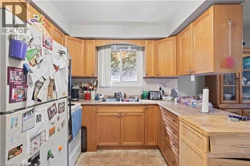 Kitchen featuring wood-finish cabinetry, solid surface countertops, and an undermount sink - 179 Vancouver Street, London, ON - Indoor Photo Showing Kitchen With Double Sink